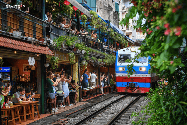 Tourists and locals pressed against the walls of Hanoi Train Street just before the train arrives