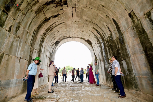 Visitors walking through Ho Dynasty Citadel stone gate