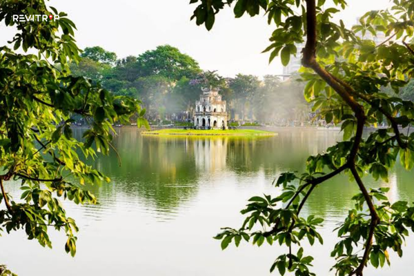 Turtle Tower on Hoan Kiem Lake framed by green trees in central Hanoi