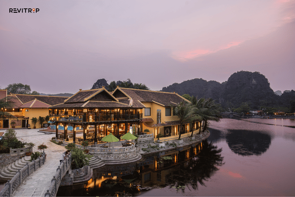 Emeralda Resort Tam Coc beside the river with limestone mountains at sunset in Ninh Binh