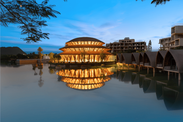Illuminated bamboo building and lakeside villas at Wyndham Grand Vedana Ninh Binh at dusk