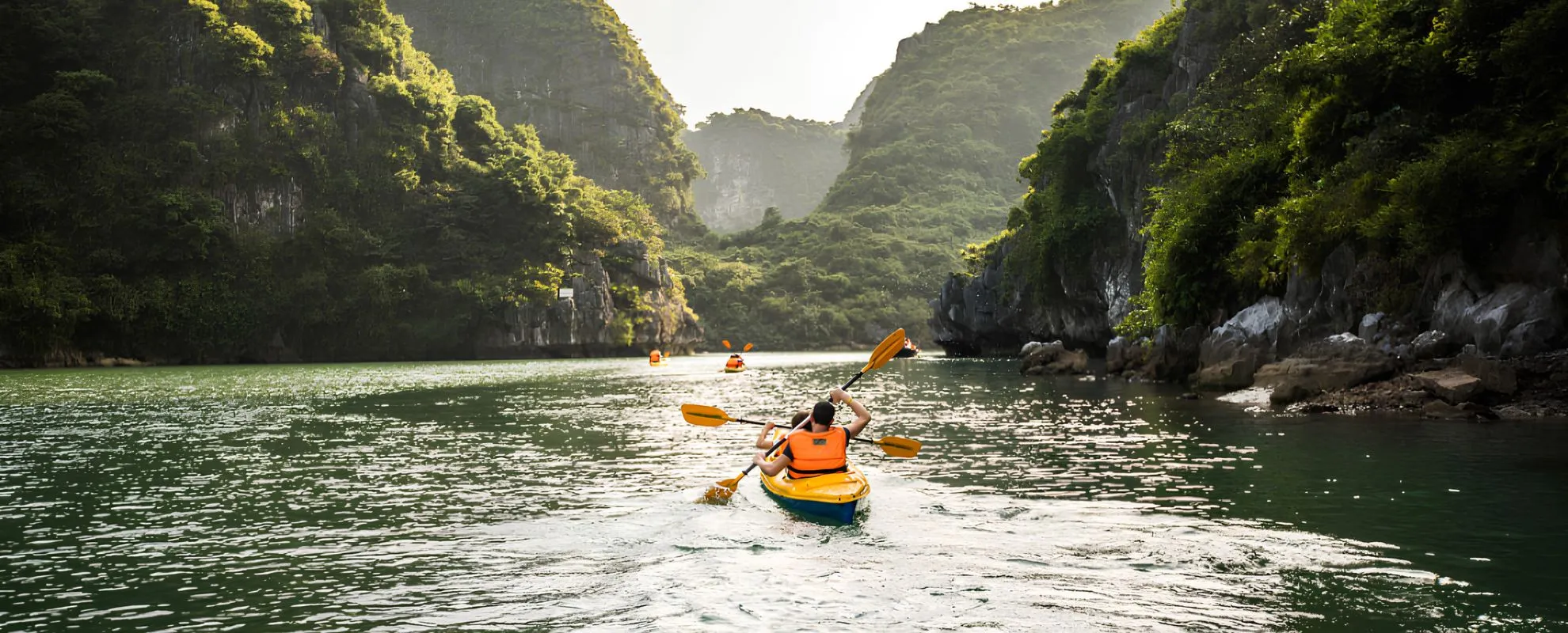 Kayaking adventure among limestone cliffs and lush scenery in Vietnam