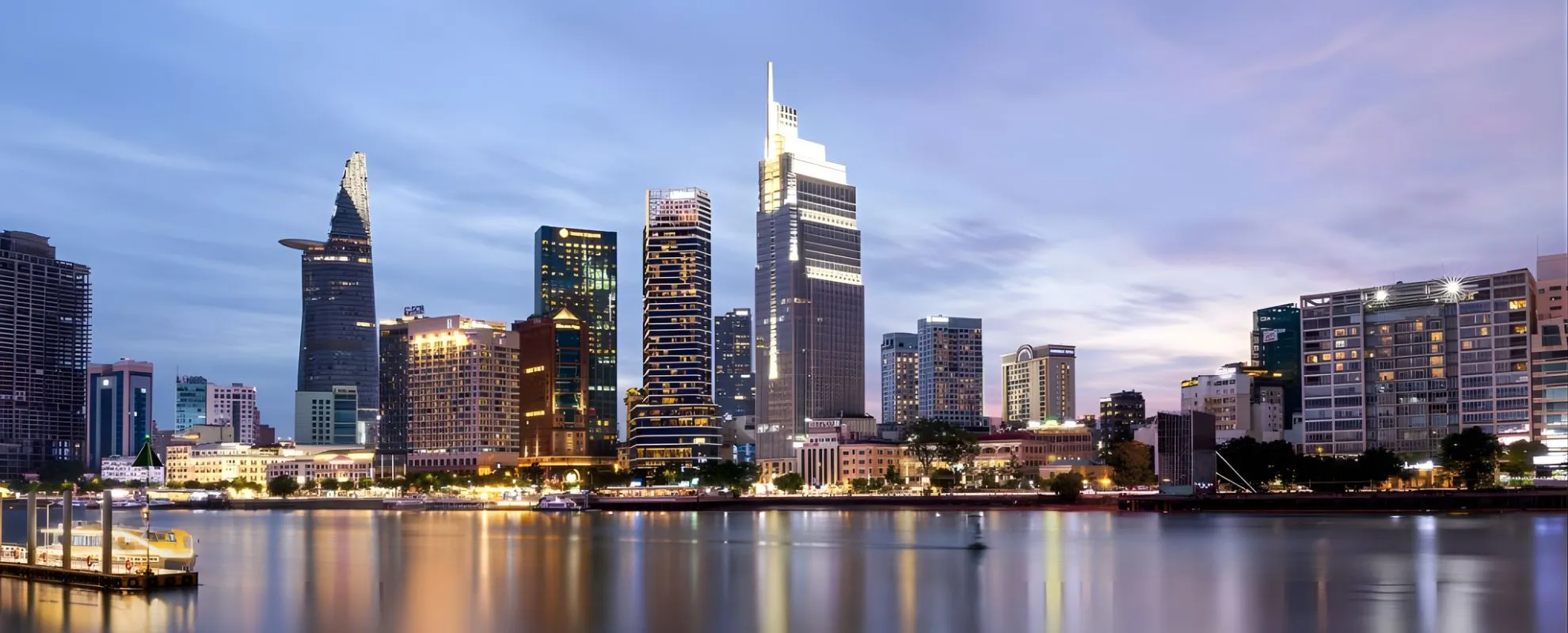 Ho Chi Minh City skyline at dusk along the Saigon River, showcasing modern skyscrapers and urban city views